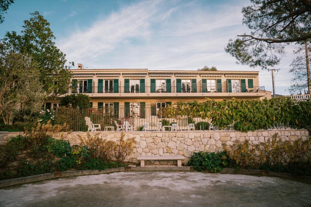a large house with a bench in front of it at Auberge du Rédier - Logis Hôtels in Colomars