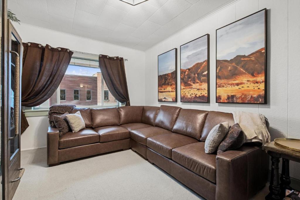ein Wohnzimmer mit einer braunen Ledercouch in der Unterkunft The Loft in Whitefish