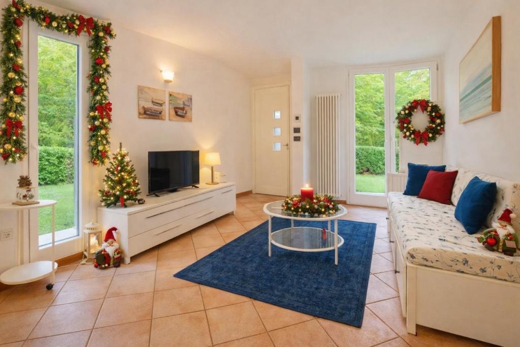 a living room with a couch and a tv at Villa Seashell in Lignano Sabbiadoro