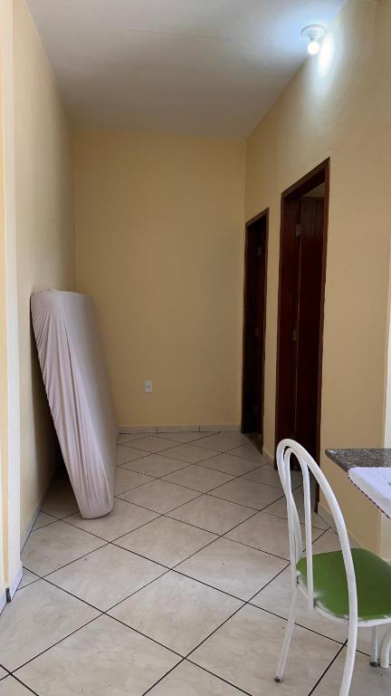 een kamer met een stoel en een matras tegen de muur bij Casa Guriri in São Mateus