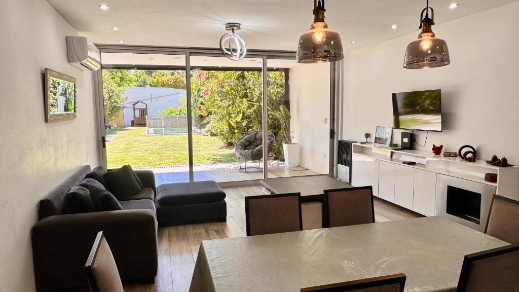 een woonkamer met een bank en een tafel bij PH tipo casa, con parque y pileta, en La Plata , barrio norte in La Plata