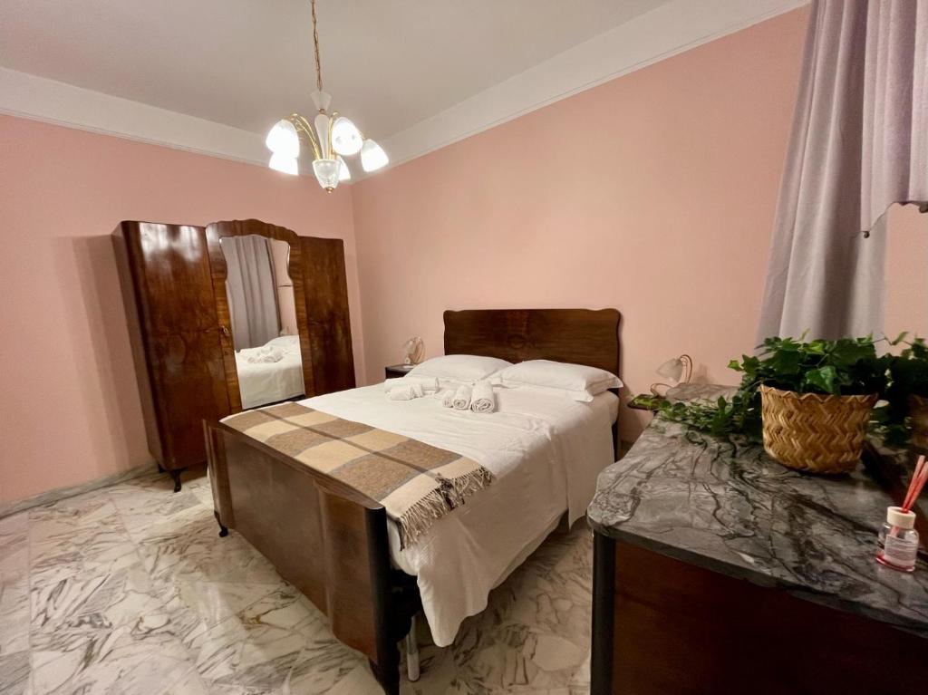 een slaapkamer met een bed in een roze kamer bij Casza me in Bronte