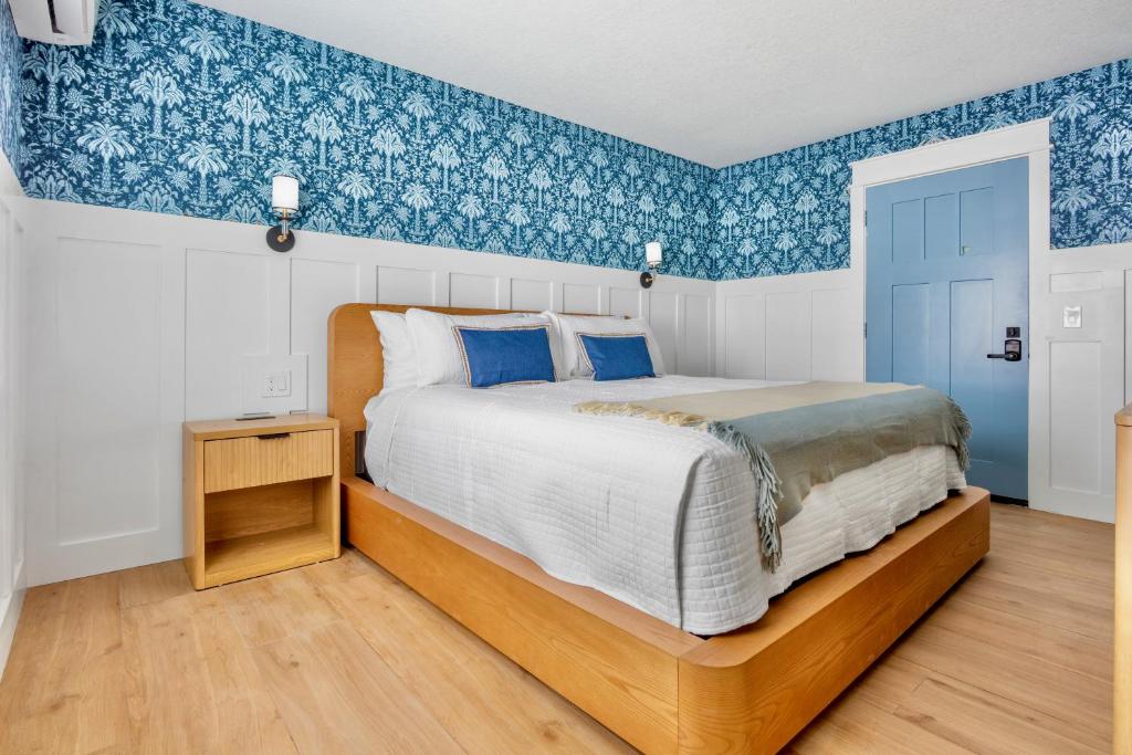 a bedroom with a large bed with blue wallpaper at Azul Resort Siesta Key in Siesta Key