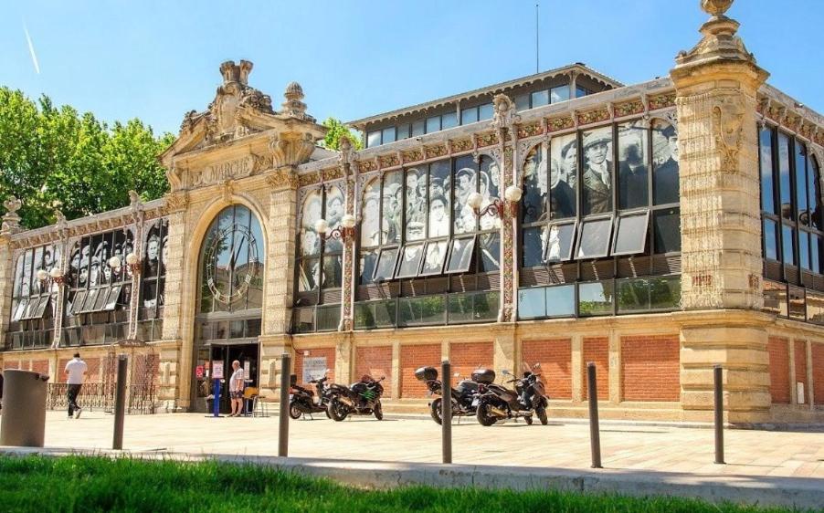 ein großes Gebäude mit Motorrädern, die draußen geparkt sind in der Unterkunft Thomas Price Appart in Narbonne