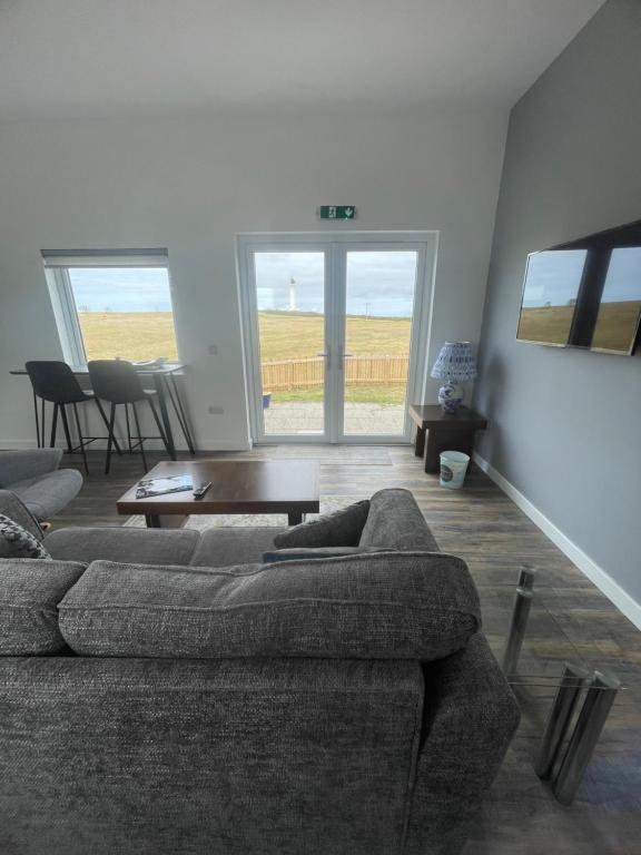 a living room with a couch and a table at 1 Lighthouse View in Lossiemouth