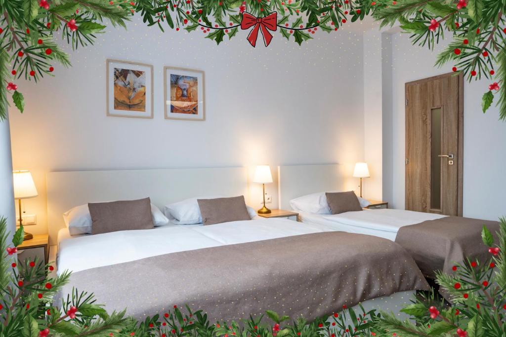 two beds in a room with christmas decorations at Petit Dependance in Bratislava