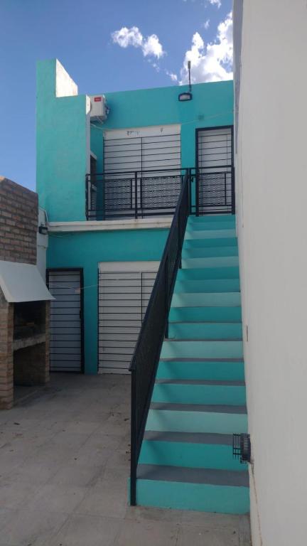 a staircase leading up to a blue building with doors at Anisados 1 in Las Grutas