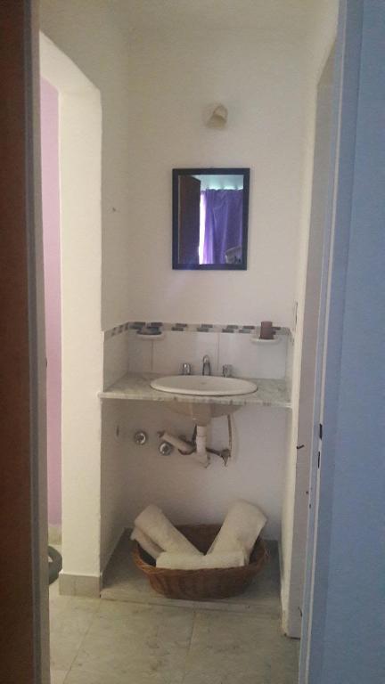 un bagno bianco con lavandino e specchio di Anisados 1 a Las Grutas