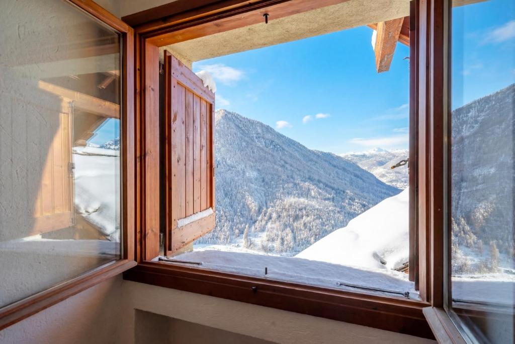 ein Fenster mit Blick auf einen schneebedeckten Berg in der Unterkunft Hostdomus-La casa di Luna in Grange Sises