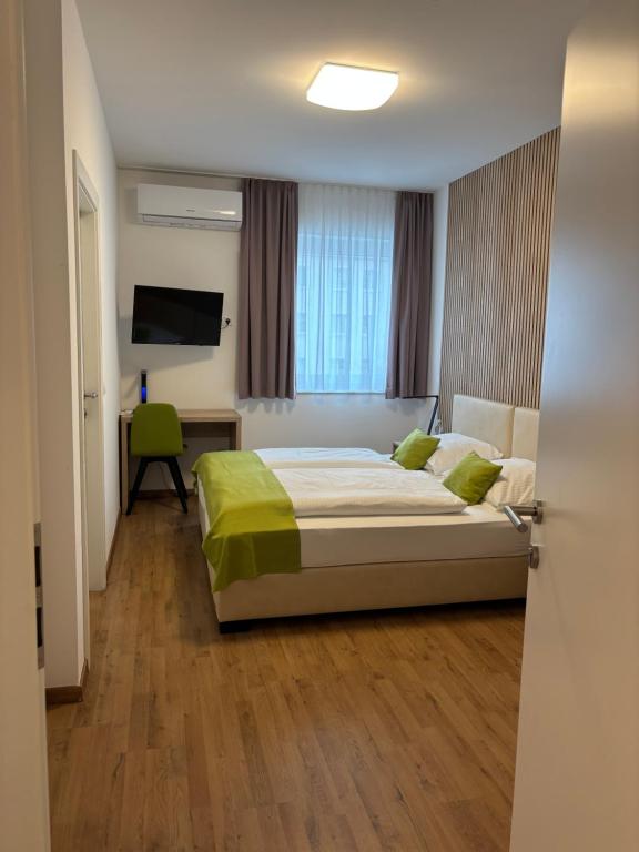 una camera d'albergo con un letto e una televisione di Hotel Garni Ilys Inn a Wels