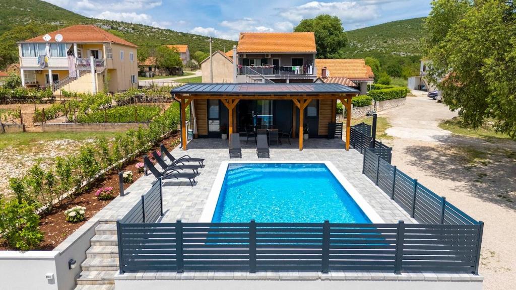 a house with a swimming pool in front of a house at Mobile Home Kapo I Exclusive Mobile Home with Private Pool in Sitno Donje