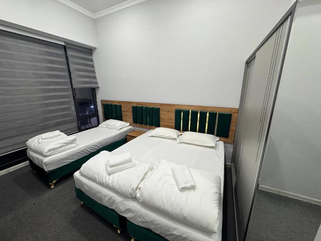 2 aparte bedden in een kamer met 2 ramen bij Vivid in Sergeli