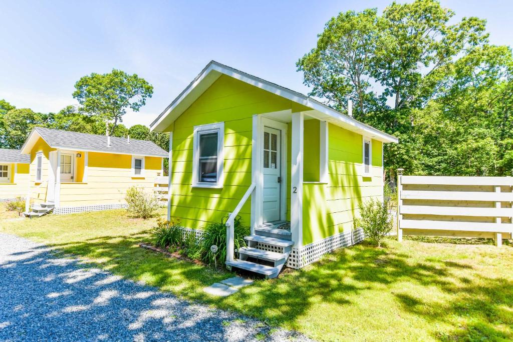 een groen en geel huis met een wit hek bij 4 Min Drive to Bayside Beaches in Eastham