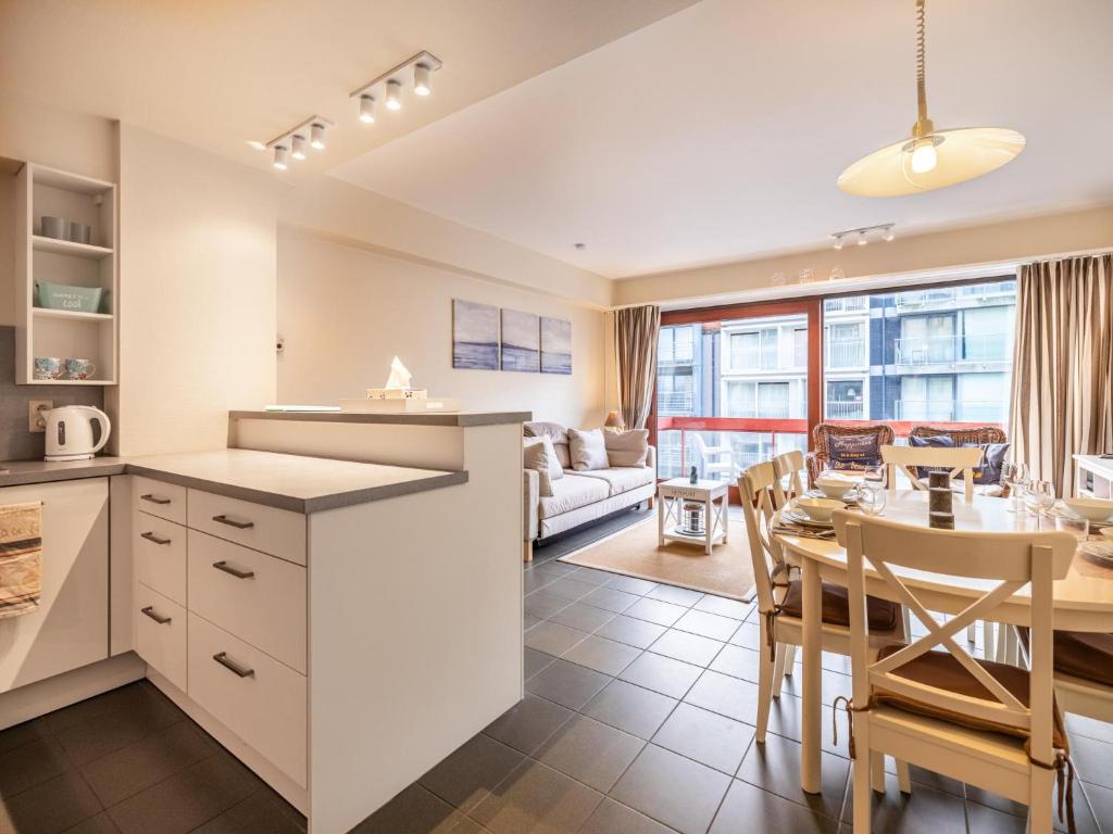 a kitchen and living room with a table and chairs at Anais derde in Sint-Idesbald
