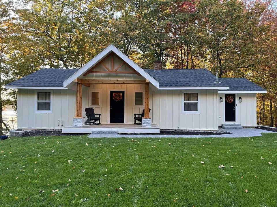 een klein wit huis met een grasveld bij Sebago Basin Getaway - An Unforgettable Experience in North Windham
