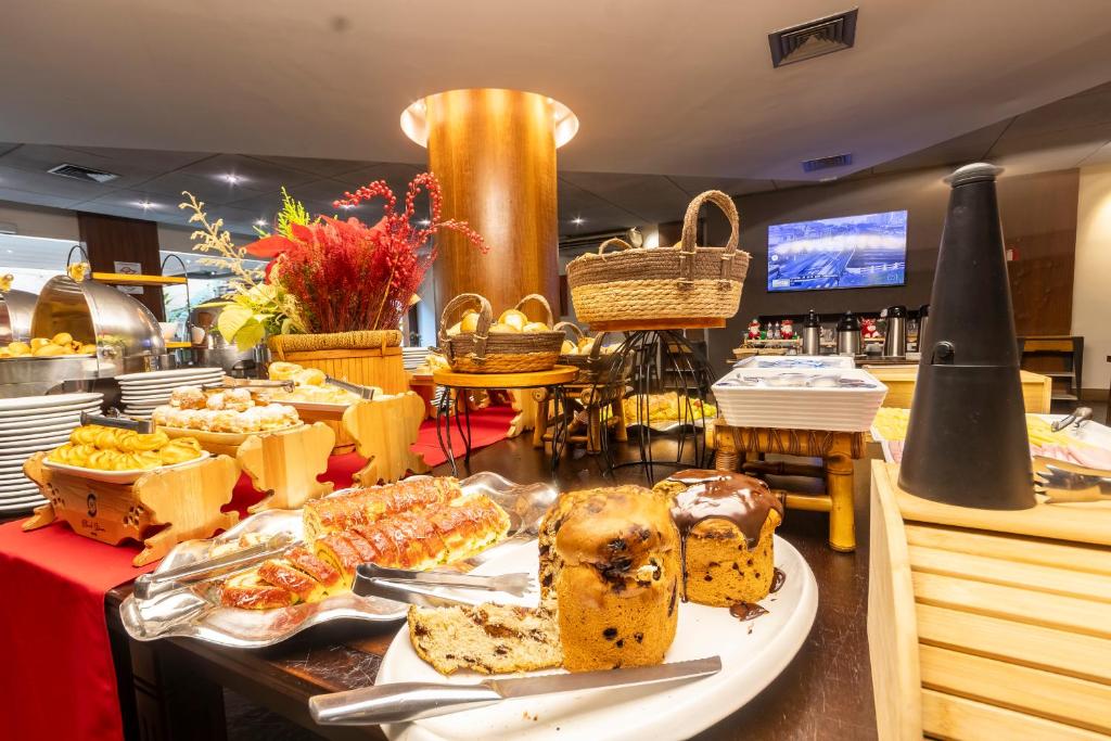 um buffet com bolos e pastelaria sobre a mesa em Stream Hotéis em Ribeirão Preto