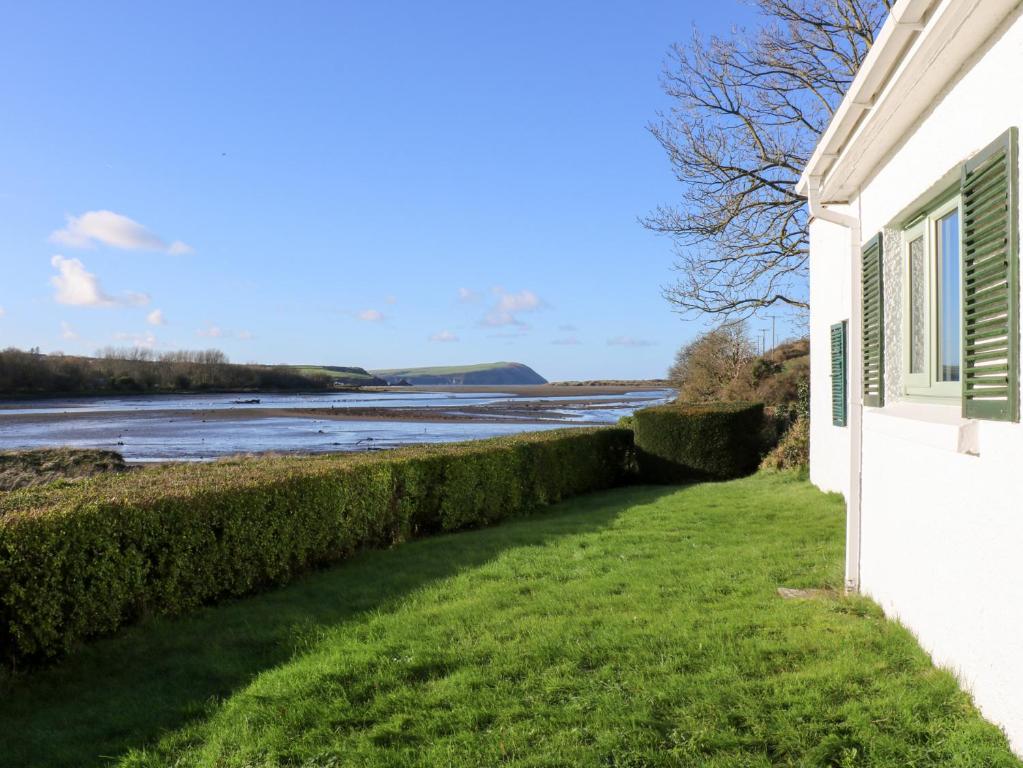 a white house with a view of the water at Bryncyn in Newport