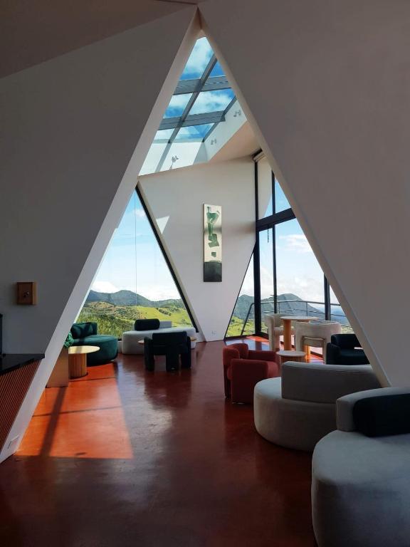 a living room with couches and chairs and windows at Ncielo Adventure Lodge in Quito