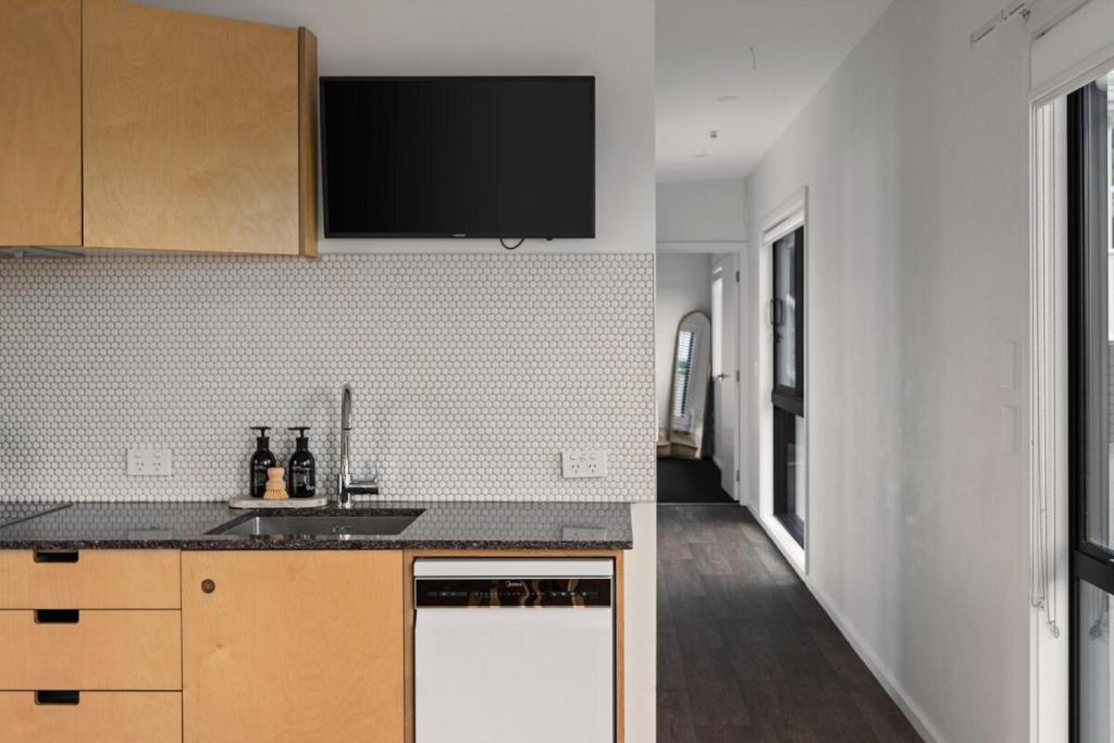 een keuken met een spoelbak en een aanrechtblad bij NEW - 2BR Beachfront unit at Okitu Beach! in Gisborne