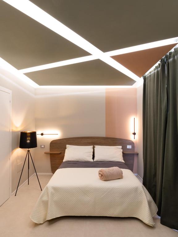 a bedroom with a large bed with lights on the ceiling at Cozy Rooms in Senorbì