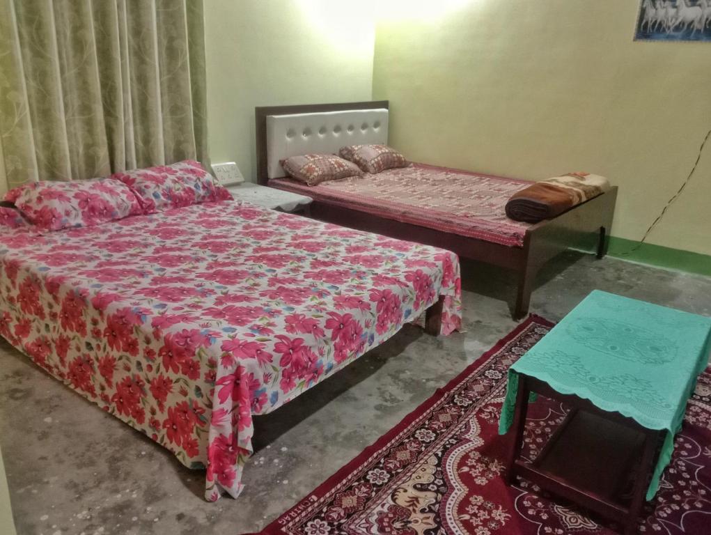 a bedroom with two beds and a table at SKY VIEW Home Stay in Siliguri