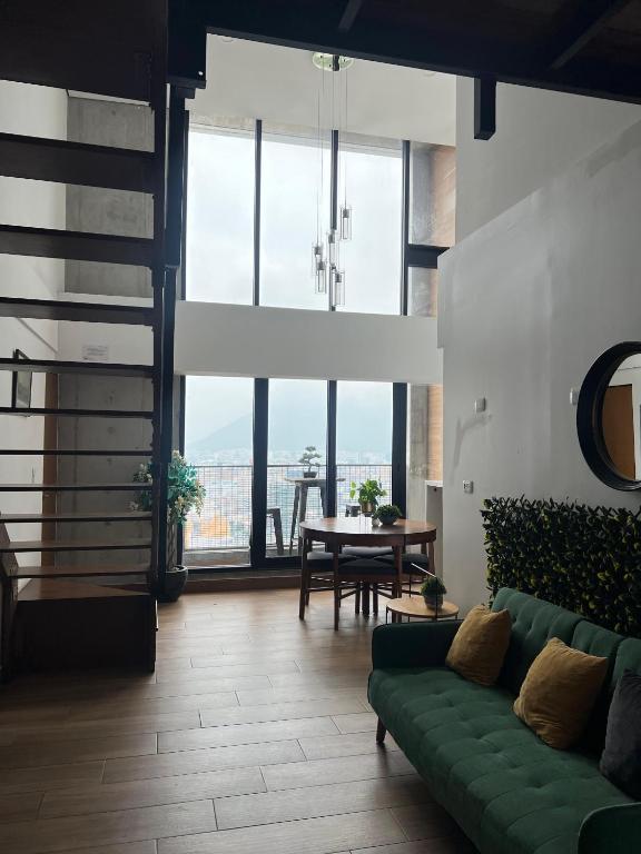 a living room with a green couch and a table at Penthouse en Centro de Monterrey in Monterrey