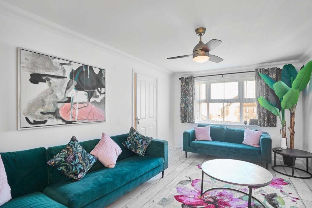 un salon avec un canapé vert et une table dans l'établissement Cornish Haven -Spacious 4 Bed House by Launceston, à Launceston