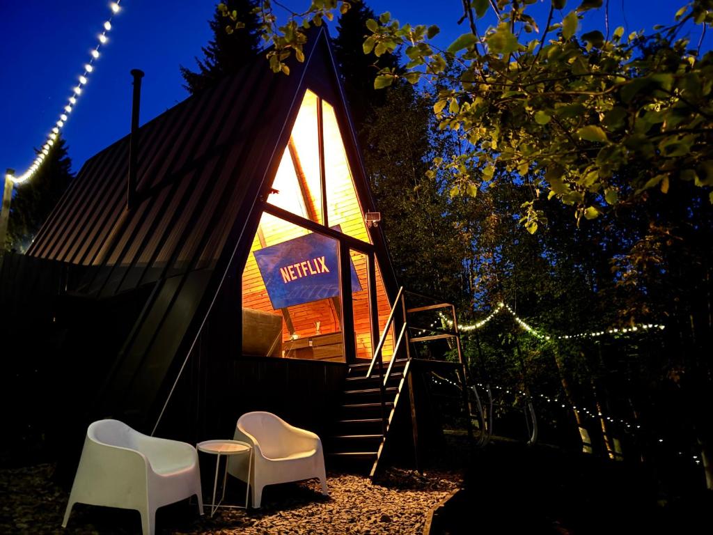 een kleine hut met twee stoelen en een bordje erop. bij M Cabin A Frame Predeal 2 Ciubar in Predeal