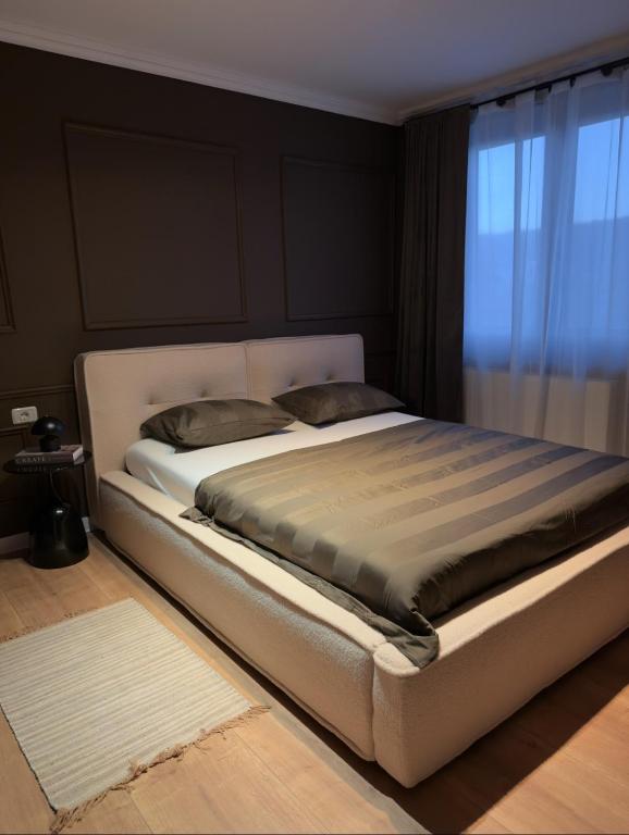 a large bed in a room with a window at Cozy Central View -Self Check-In 24h in Reşiţa