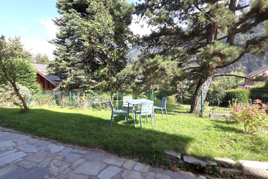 une table et des chaises dans l'herbe dans une cour dans l'établissement Appartement 2 pers hyper centre Chamonix, à Chamonix-Mont-Blanc