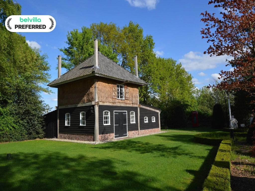 an old house on a grassy field with trees at Cozy holiday home in Volkel with Sauna in Volkel