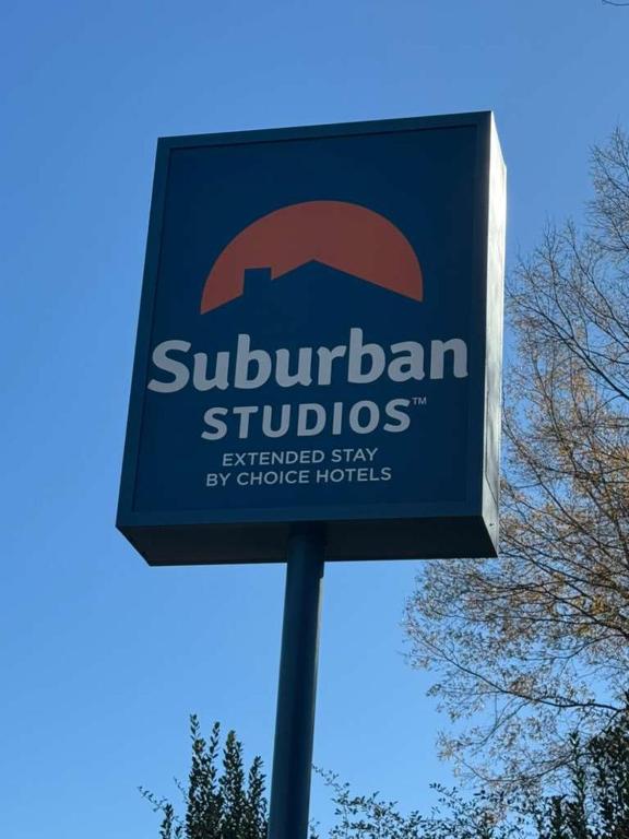 a blue sign for a subaru studiosennisquartered stay by choicelords at Suburban Studios Winston-Salem near Hanes Mall in Winston-Salem