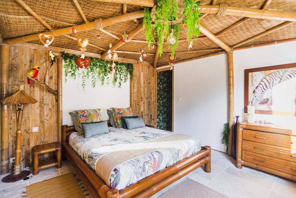 Gîtes Mas des rochers - Case bambou avec Spa في لو بوزيت: غرفة نوم بها سرير في الغرفة