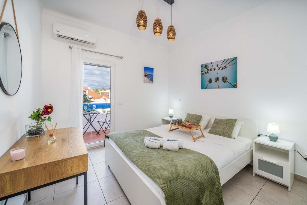 una camera da letto con un letto, una scrivania e una finestra di Sunlit Balcony & Open Space Flat by HostWise a Vale de Pedras