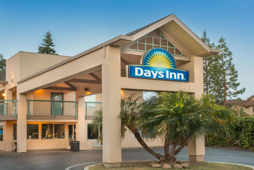 un día de señal de posada frente a un edificio en Days Inn by Wyndham Redwood City, en Redwood City