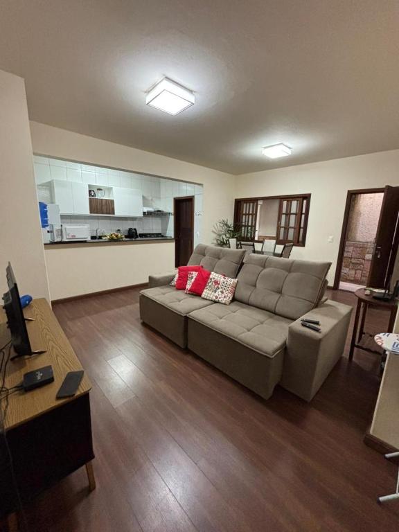 a living room with a couch and a kitchen at Morada Alecrim in Diamantina