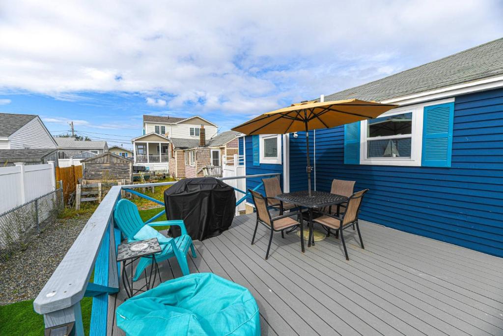 a deck with a table and chairs and an umbrella at Blue Chill in Hampton