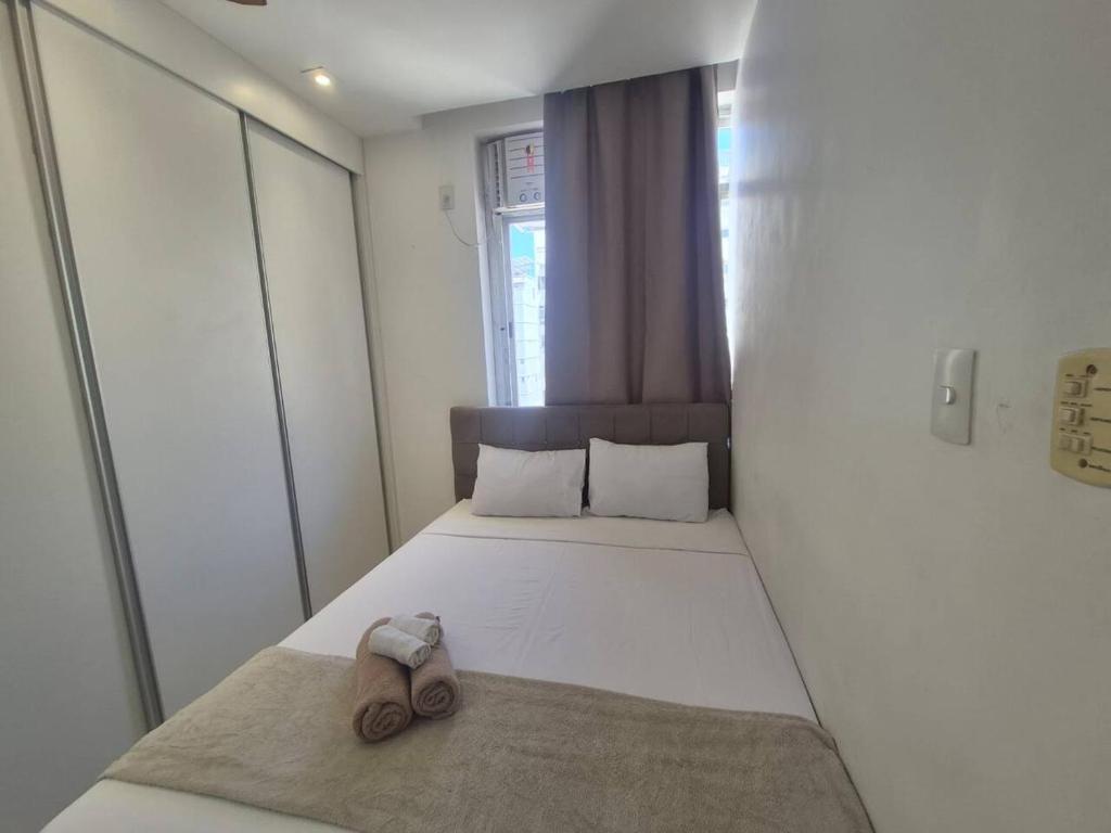 een slaapkamer met een bed met een paar schoenen erop bij SUH Copacabana 143 in Rio de Janeiro