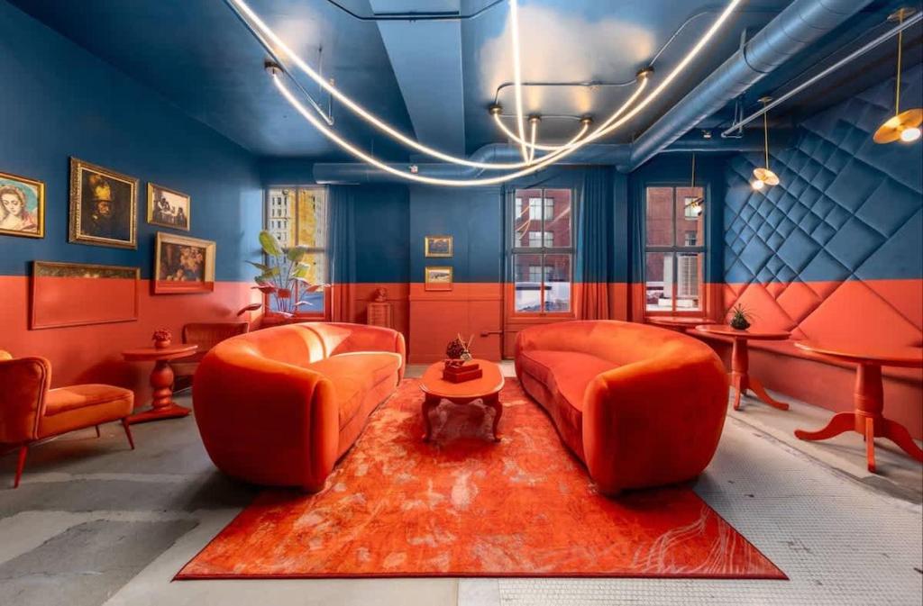 ein Wohnzimmer mit orangefarbenen Stühlen und einem roten Teppich in der Unterkunft Symons Block Suite 4 in Spokane