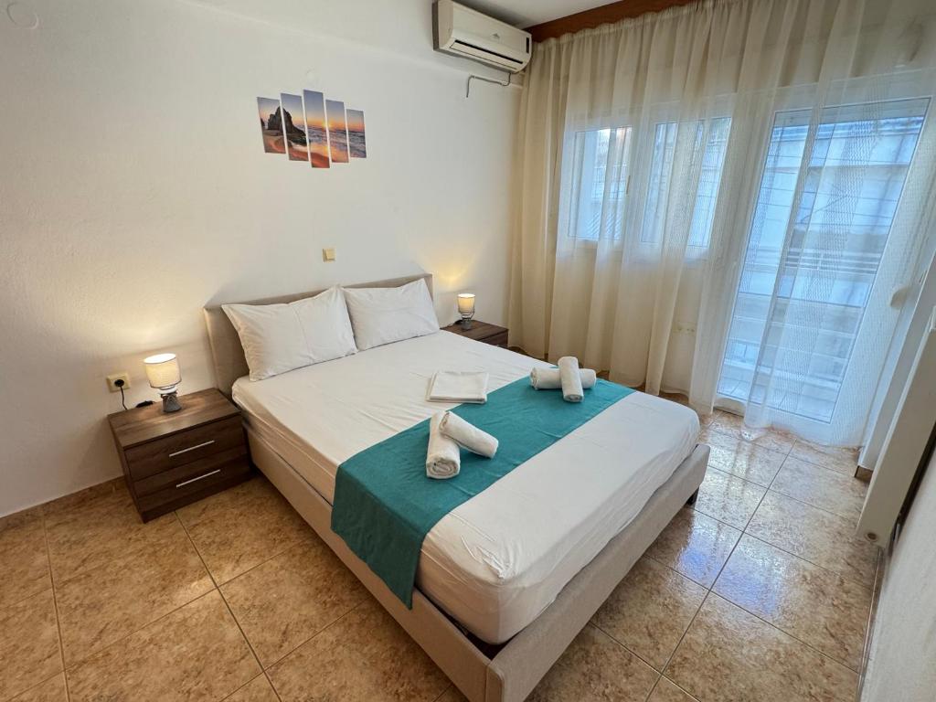 a bedroom with a large bed with towels on it at Dimado Family in Kavála