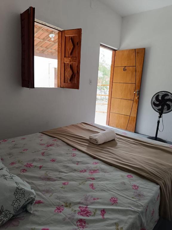 a bedroom with a bed and a window and a door at Oásis in Beberibe