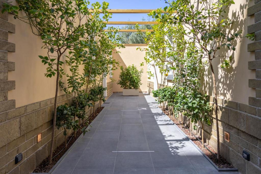 een loopbrug in een gebouw met bomen aan de zijkant bij Prince Residence in Castellammare di Stabia