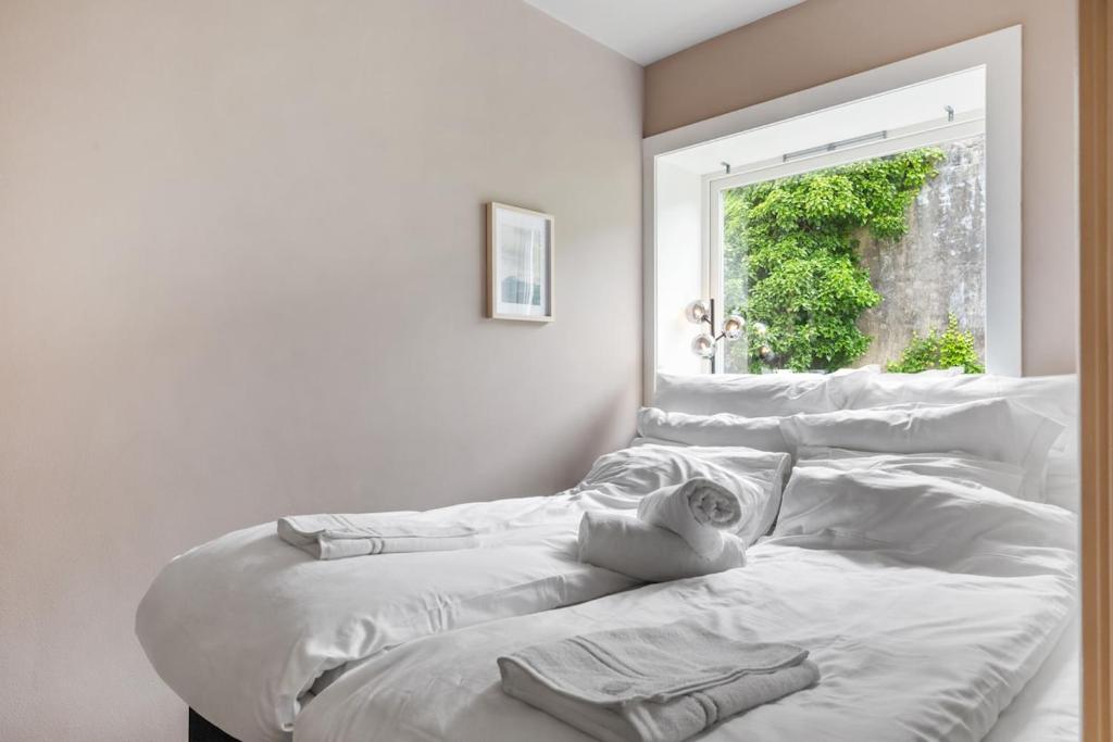 een bed met witte lakens in een kamer met een raam bij Apartment in Bergen in Bergen