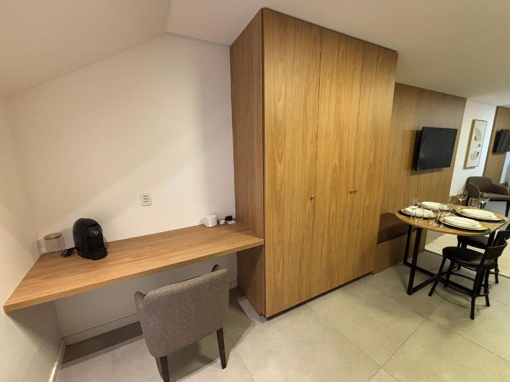 a room with a desk and a table with chairs at Estúdios Completos no Centro de Floripa - CMA in Florianópolis