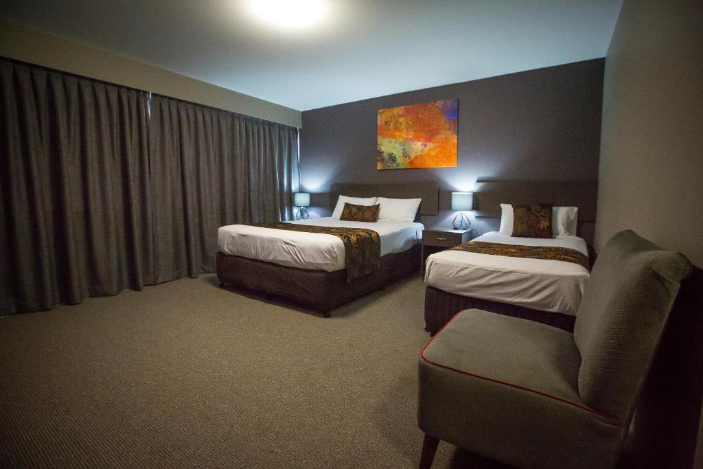Postel nebo postele na pokoji v ubytování Gladstone Reef Hotel Motel