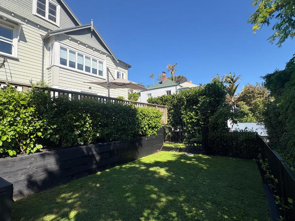 een huis met een hek en een tuin bij Auckland City Villa in Auckland
