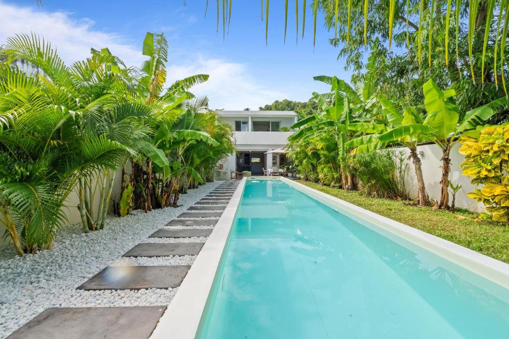 a swimming pool in front of a house with palm trees at Casa Blanca in La Trinité