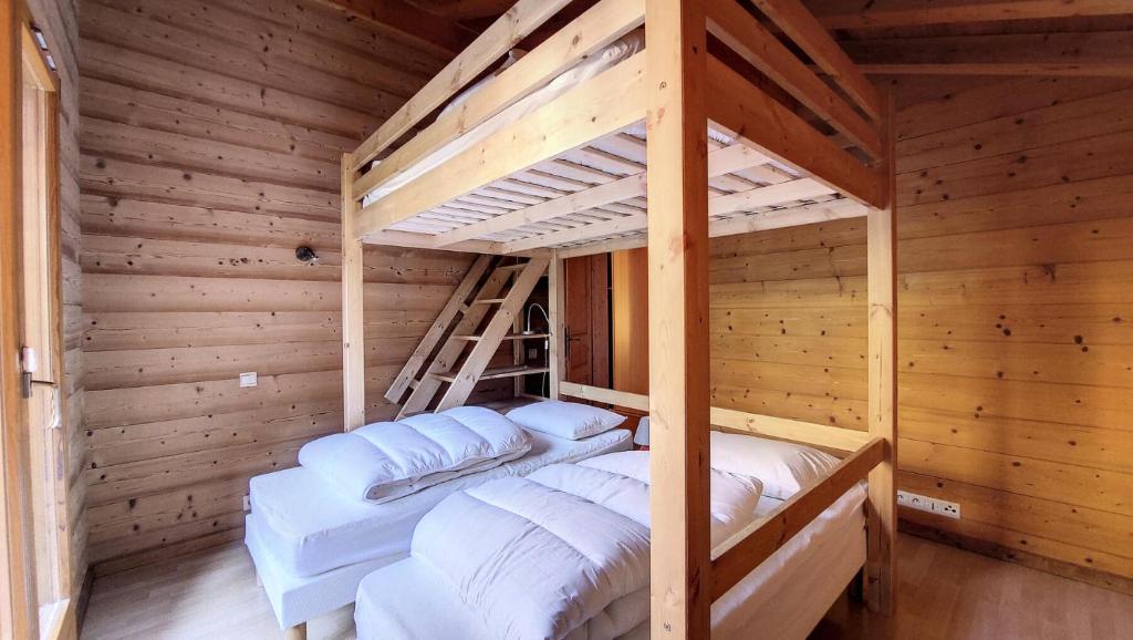 een slaapkamer met 2 stapelbedden in een houten kamer bij Chalets à Saint Jean d'Aulps - Chalet MB MAE-4101 in Saint-Jean-dʼAulps