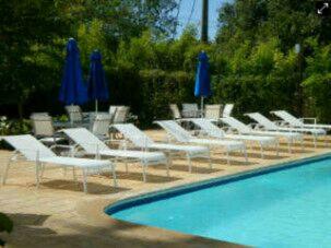 - un groupe de chaises longues et de parasols bleus à côté d'une piscine dans l'établissement 2 bedrooms, 2 bathrooms, pool and near from the beach, à Juan Dolio