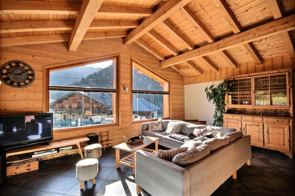 een woonkamer met een bank en een tv bij Chalets à Saint Jean d'Aulps - Coffy MAE-3601 in Saint-Jean-dʼAulps
